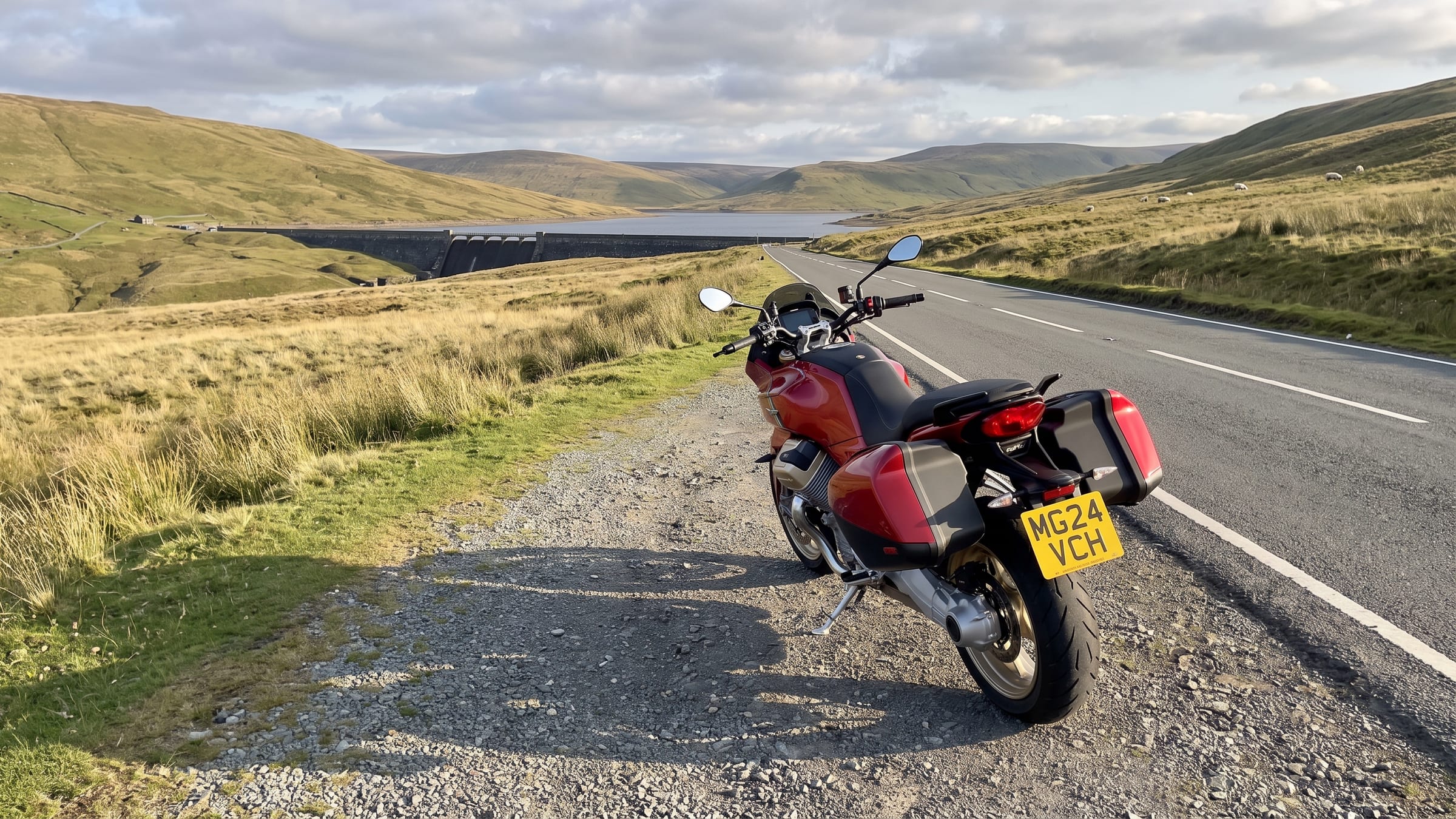 A motorcycle beside a mountain road above a reservoir dam in Mid Wales
