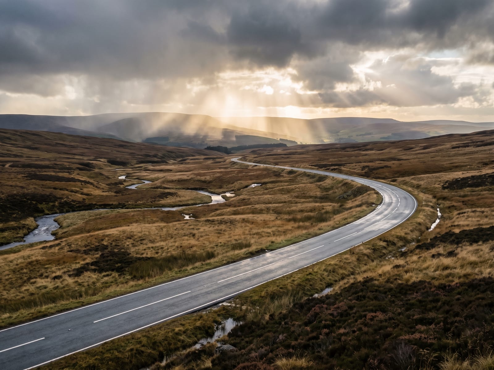 Near Buxton: a wide sweeping tarmac road crossing bleak upland moorland in the Peak District, Derbyshire