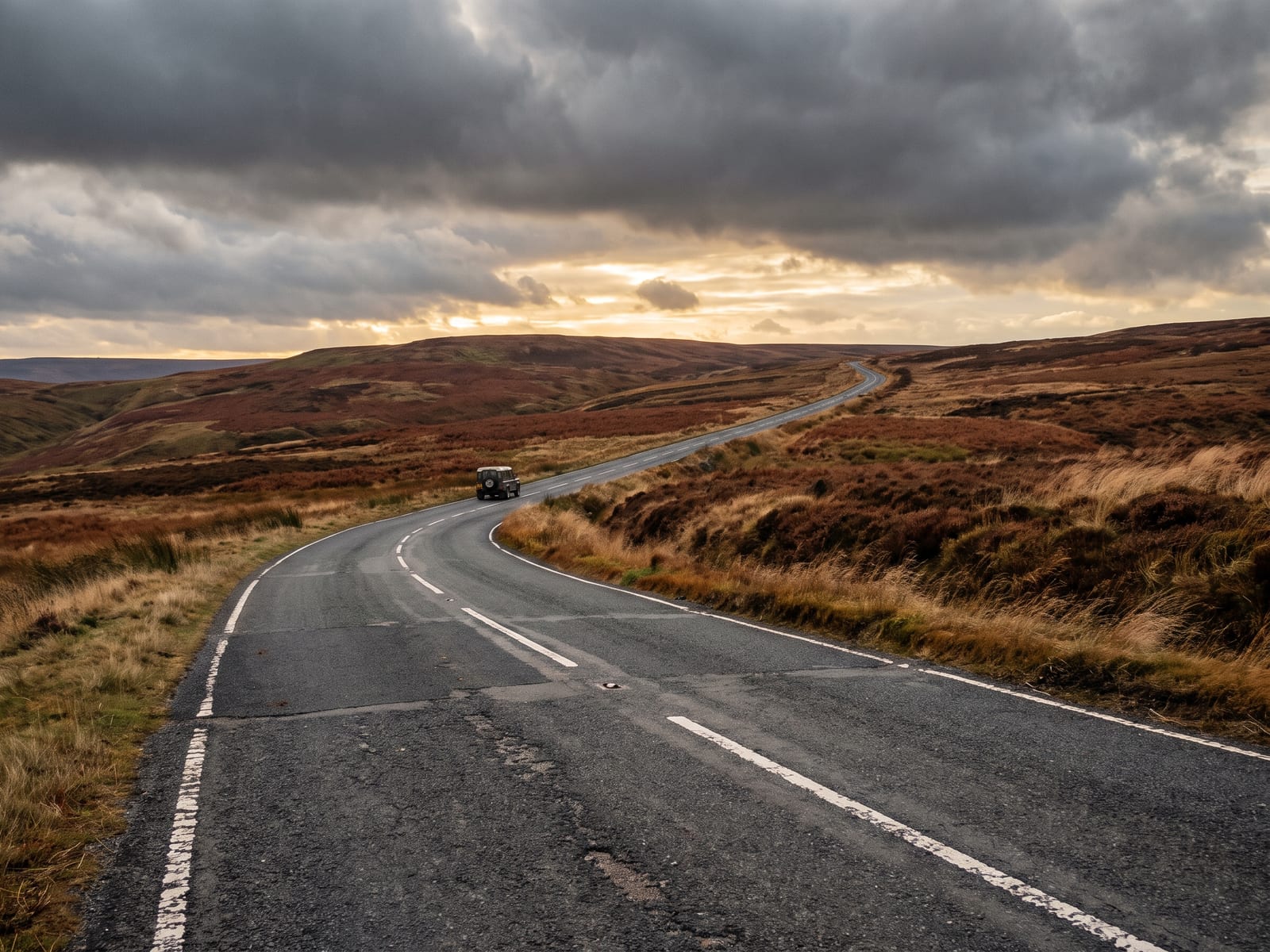 Near Glossop: a long tarmac road climbing across wild high moorland in the Dark Peak, Derbyshire