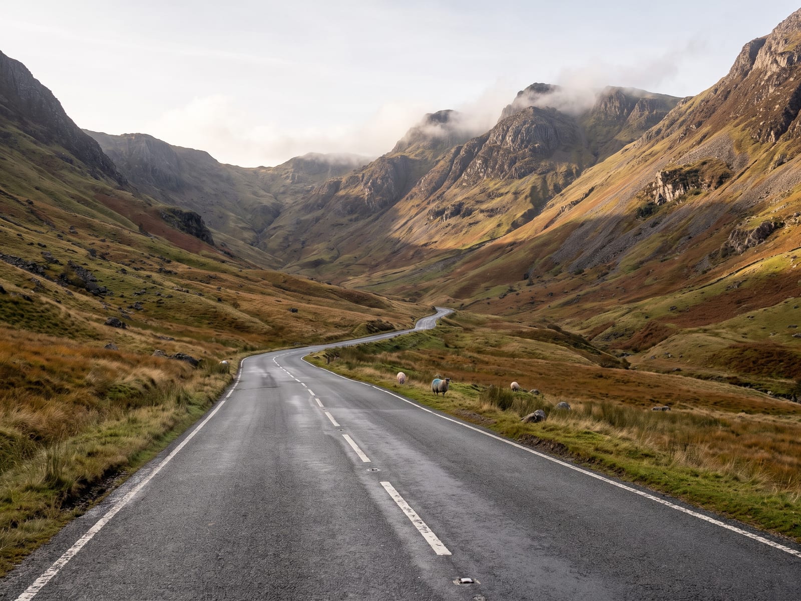 Near Keswick: a two-lane road winding up a steep-sided glacial valley towards a high pass in the Lake District, Cumbria