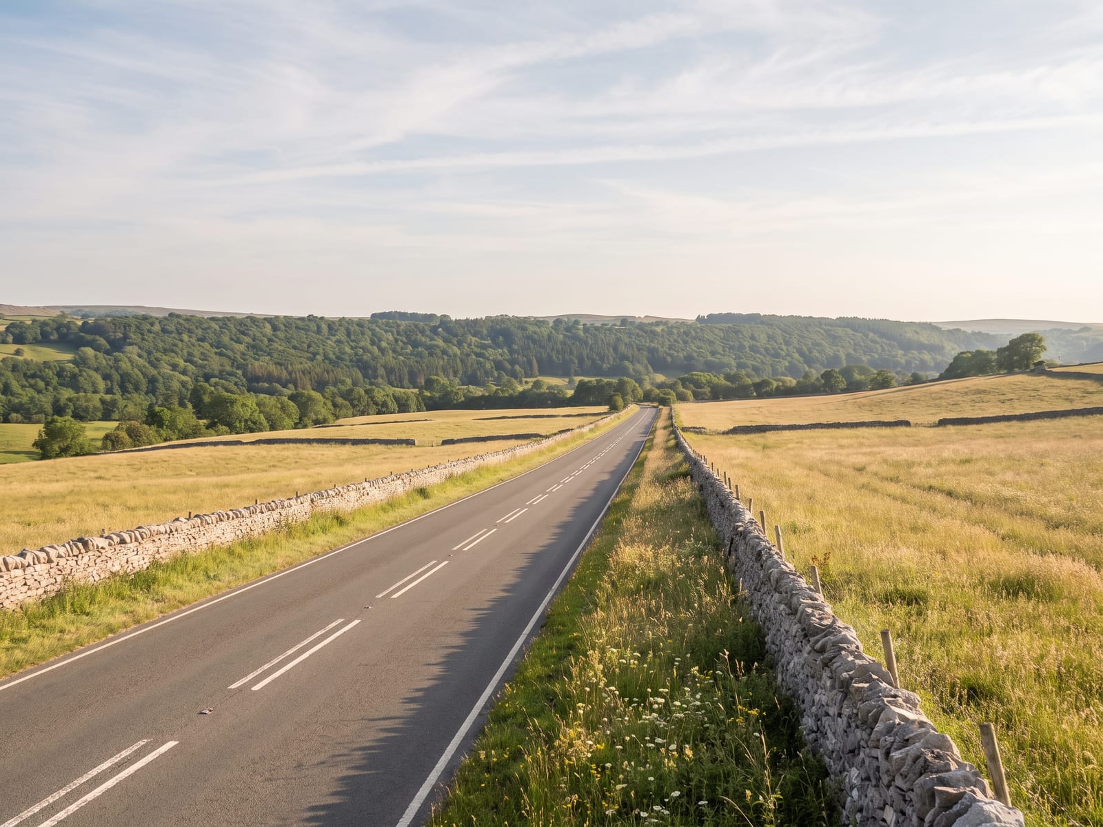 Near Matlock Bath: a smooth tarmac road crossing high limestone farmland in the White Peak, Derbyshire